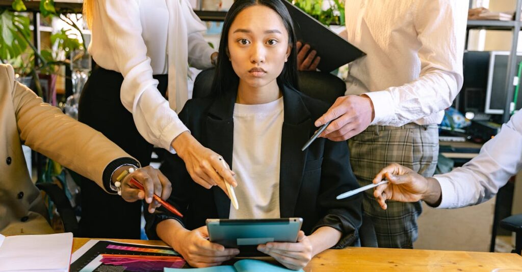 An overwhelmed office worker surrounded by colleagues requesting her attention during a busy workday.