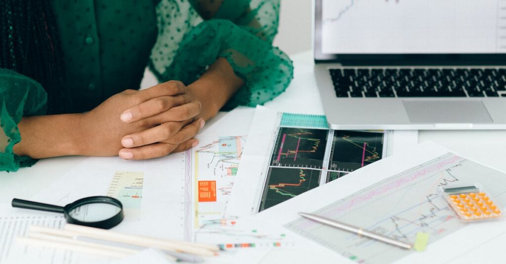 A person analyzes financial charts and graphs at a desk, indicating business trading activity.